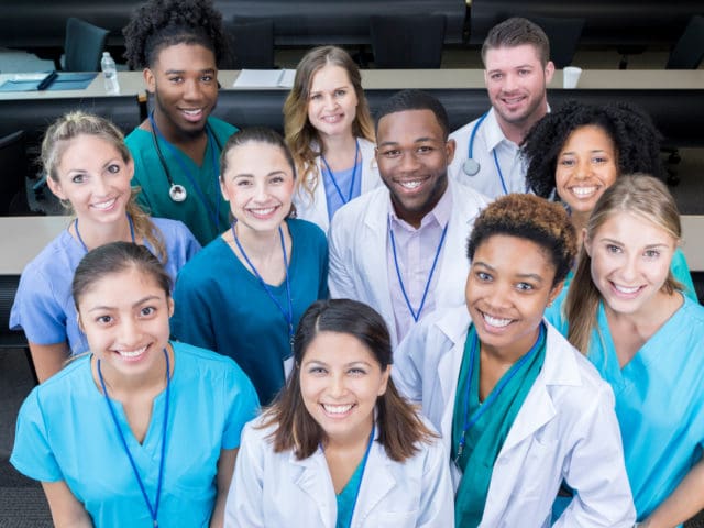 A group of young doctors and nurses posing for a picture