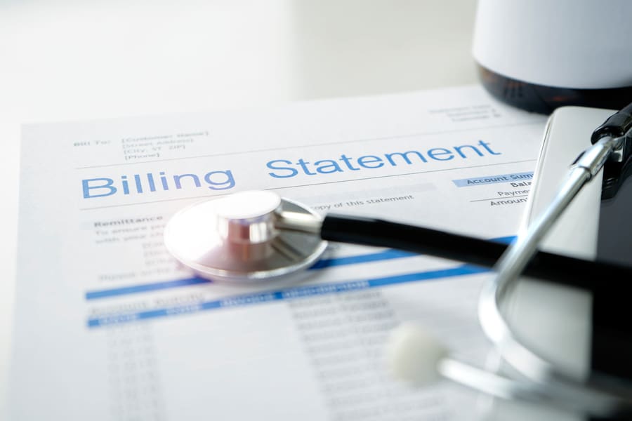 Outsourced Billing for Primary Care Doctors - billing statement and stethoscope on doctor's desk